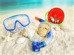 Water goggles and beach toys in the sand