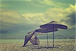 Old sunshade on deserted beach out of season in sunny day