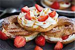 Cream puff rings (choux pastry) decorated with fresh strawberry and caramel sauce