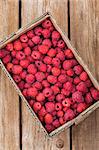 Fresh organic ripe raspberry in box on wooden table