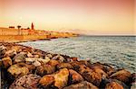 Alghero, Sardinia: skyline of the city with defensive walls in the beautiful sunset