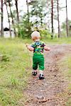 Small boy walking on path in forest