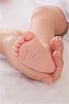 Mothers hand holding baby boys foot