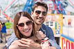 Couple wearing sunglasses looking at camera smiling, Coney island, Brooklyn, New York, USA