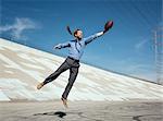 Businessman catching american football on Los Angeles river, California, USA