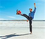 Businessman playing with soccer ball on Los Angeles river, California, USA