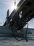 Businessman skipping, Los Angeles river, California, USA