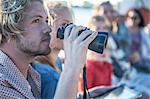 Young tourist couple with binoculars on boat trip, Cape Town, South Africa