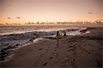 Boy and sister running on beach at sunrise, Blowing Rocks Preserve, Jupiter Island, Florida, USA