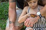 Father and daughter looking at monarch butterfly