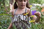 Girl looking at monarch butterfly on flower