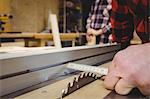 Carpenter measuring wood plank in workshop