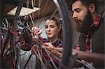 Mechanics repairing a bicycle in workshop