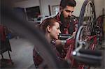 Mechanics repairing a bicycle in workshop