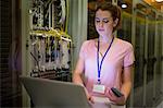 Technician using laptop in server room