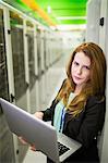 Portrait of technician using laptop in server room