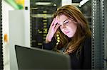 Technician using laptop in server room