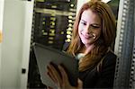 Technician using digital tablet in server room