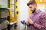 Technician holding digital cable analyzer in server room