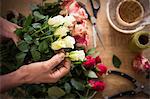 Close-up of male florist preparing bouquet of flower at his flower shop