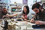 Happy woman with male colleagues working at workshop