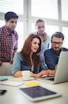 Businesswoman with coworkers in meeting room at creative office