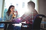 Happy woman looking at disabled boyfriend at cafe