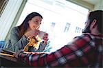 Happy young woman looking at disabled man at cafe