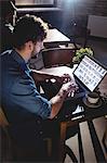 Side view of young man typing on laptop at coffee shop