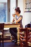 Casual woman using a smartphone in a cafe