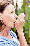 Close-up of woman using asthma inhaler