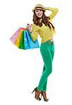 Colourful shopping vibes. Full length portrait of smiling brunette woman in hat and bright clothes with shopping bags on white background