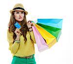 Colourful shopping vibes. Portrait of thoughtful brunette woman in hat and bright clothes with colorful shopping bags and credit card on white background