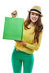 Colourful shopping vibes. Portrait of smiling brunette woman in hat and bright clothes showing green shopping bags on white background