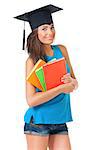 Beautiful girl with graduation hat holding book, isolated on white background