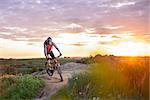 Cyclist Riding the Bike on the Mountain Rocky Trail at Sunset. Extreme Sports