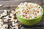 Sweet Caramel Popcorn in Green Bowl on Wooden Background, Selective Focus, Unhealthy Food Concept