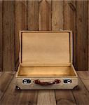 Vintage suitcase opened on rough wooden plank background