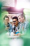 Men and women texting with cell phone in cafeteria