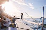 Man adjusting sailing winch on sailboat