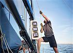 Man adjusting sailing equipment on sailboat