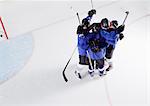 Hockey team in blue uniforms cheering celebrating on ice