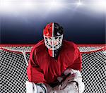 Portrait determined hockey goalie protecting goal net