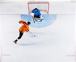 Hockey player shooting the puck at goal net