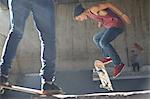 Teenage boy flipping skateboard at skate park