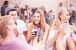 Young friends hanging out drinking at music festival