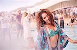 Portrait young woman dancing at poolside party