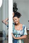 Woman leaning in doorway, smiling, portrait