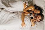 Couple taking selfie with smartphone while lying in bed