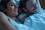 Couple watching tv together in bed